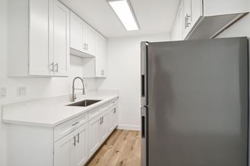 El Cajon apartment for rent - A modern kitchen with white cabinets and a black refrigerator.