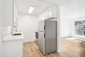 El Cajon apartment for rent - A kitchen with a refrigerator, sink, and cabinets.