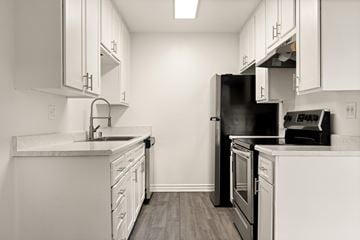 El Cajon apartment for rent - A kitchen with white cabinets and a black refrigerator.