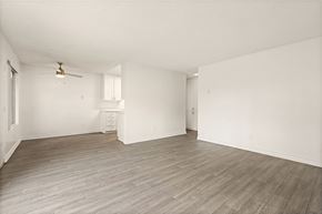 El Cajon apartment for rent - A room with a ceiling fan and light fixture, a small white cabinet, and a wooden floor.