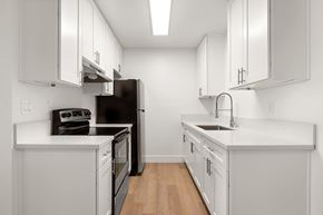 El Cajon apartment for rent - A kitchen with white cabinets and a black refrigerator.