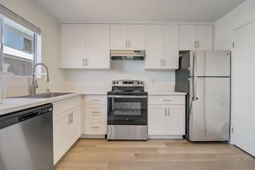 El Cajon apartment for rent - A kitchen with white cabinets and stainless steel appliances.
