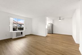 Ramona apartment for rent - A room with wooden flooring and a window showing a view of a building.