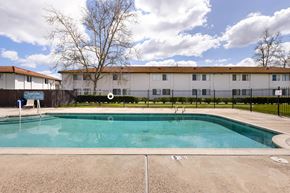 Ramona apartment for rent - A swimming pool in front of a building with a fence around it.