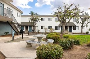 El Cajon apartment for rent - A courtyard with a bench, a table and a tree.