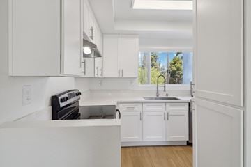 Ramona apartment for rent - A modern kitchen with white cabinets and appliances.