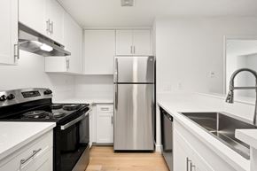 El Cajon apartment for rent - A modern kitchen with a stainless steel refrigerator and black countertops.