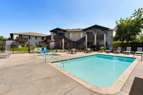 El Cajon apartment for rent - A large swimming pool in front of a multi-story apartment building.