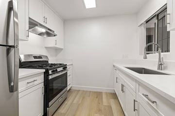 El Cajon apartment for rent - A modern kitchen with white cabinets and stainless steel appliances.