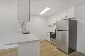 Ramona apartment for rent - A kitchen with a refrigerator, sink, and cabinets.
