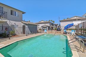 Ramona apartment for rent - A swimming pool surrounded by a fence and chairs.