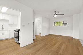 El Cajon apartment for rent - A spacious kitchen with wooden floors and white walls.