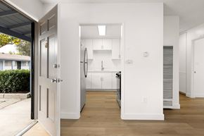 El Cajon apartment for rent - A white kitchen with a refrigerator, sink, and cabinets.