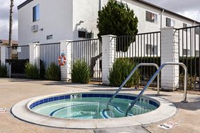 El Cajon apartment for rent - A small pool in front of a white building with a black fence.