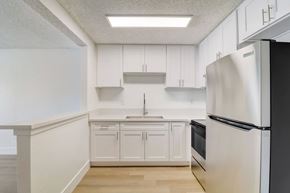 El Cajon apartment for rent - A kitchen with white cabinets and a black refrigerator.