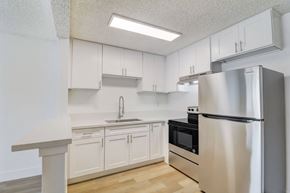 El Cajon apartment for rent - A kitchen with white cabinets and a stainless steel refrigerator.