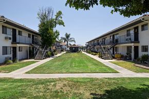 Ramona apartment for rent - A row of apartment buildings with green lawns in front.