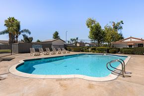 Ramona apartment for rent - A swimming pool with a diving board and lounge chairs.