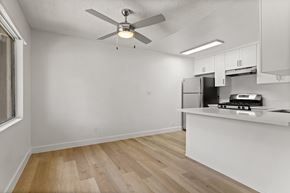 El Cajon apartment for rent - A kitchen with a white ceiling fan and wooden floors.
