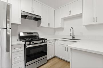 El Cajon apartment for rent - A modern kitchen with white cabinets and stainless steel appliances.