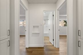 El Cajon apartment for rent - A white hallway with wood floors and white walls.