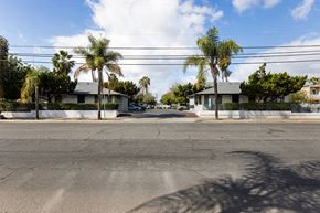 El Cajon apartment for rent - A street view with houses and palm trees.