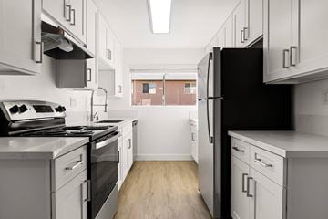 Spring Valley apartment for rent - A kitchen with white cabinets and a black refrigerator.