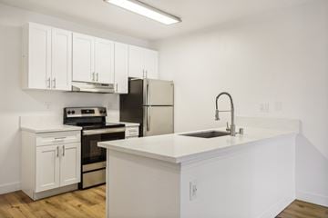 Spring Valley apartment for rent - A kitchen with white cabinets and appliances.