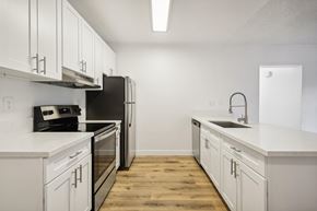Spring Valley apartment for rent - A kitchen with white cabinets and a black fridge.