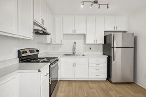 Spring Valley apartment for rent - A modern kitchen with white cabinets and stainless steel appliances.