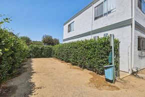 Spring Valley apartment for rent - A white building with a green trash can in front of it.