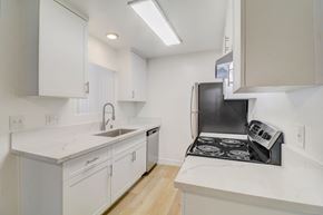 Spring Valley apartment for rent - A kitchen with white cabinets and a black stove top oven.