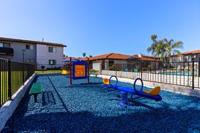 Escondido apartment for rent - A playground with a blue slide and a yellow swing set.