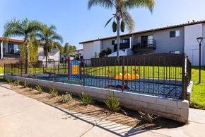 Escondido apartment for rent - A pool surrounded by a black fence with a small orange boat in the water.