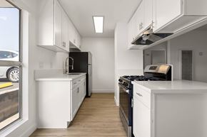 La Mesa apartment for rent - A modern kitchen with white cabinets and black appliances.