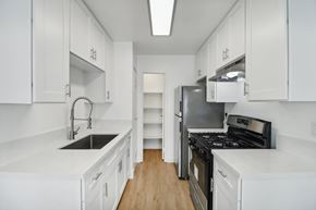 Escondido apartment for rent - A kitchen with white cabinets and black appliances.