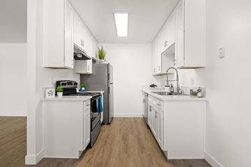 Escondido apartment for rent - A kitchen with white cabinets and a wooden floor.