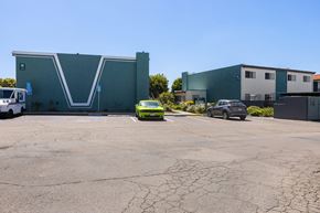 Escondido apartment for rent - A green car is parked in front of a grey building.
