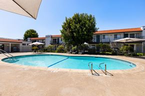 Escondido apartment for rent - A swimming pool surrounded by a fence and a tree.