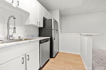 Escondido apartment for rent - A kitchen with white cabinets and a black refrigerator.