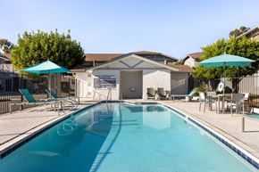 San Diego apartment for rent - A swimming pool with a blue umbrella and chairs.