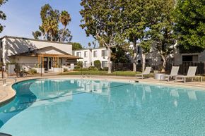 Spring Valley apartment for rent - A swimming pool in front of a house with trees in the background.