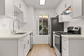 Spring Valley apartment for rent - A kitchen with white cabinets and a black refrigerator.