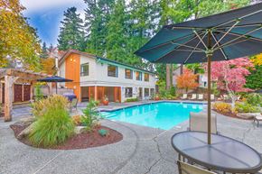 Lynnwood apartment for rent - A pool with a table and chairs and a house in the background.