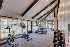 Federal Way apartment for rent - A gym with a variety of equipment including a treadmill, stationary bike, and dumbbells.