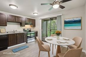 Federal Way apartment for rent - A kitchen with brown cabinets and a dining table set for four.