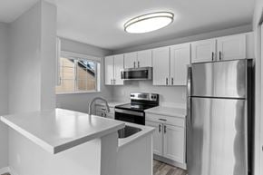 Kent apartment for rent - A modern kitchen with white cabinets and stainless steel appliances.