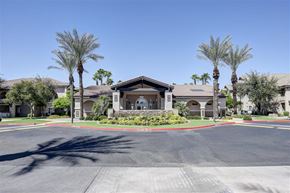 Gilbert apartment for rent - A building with palm trees in front of it.