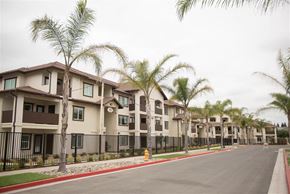Stockton apartment for rent - A row of houses with palm trees in front.