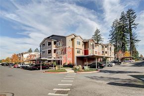 Olympia apartment for rent - A large apartment complex with a parking lot in front.